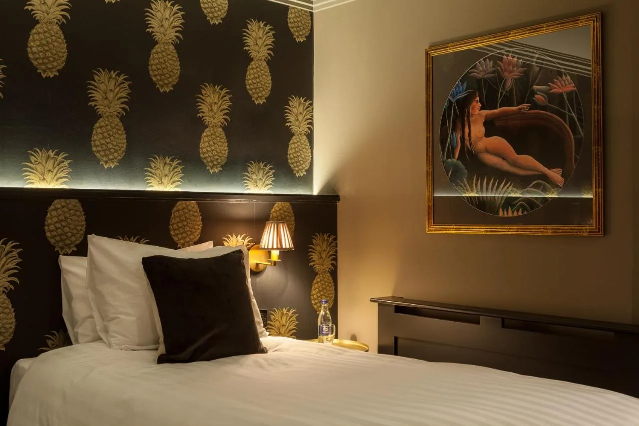 a bedroom with a bed and a painting on the wall at House Belfast Hotel in Belfast