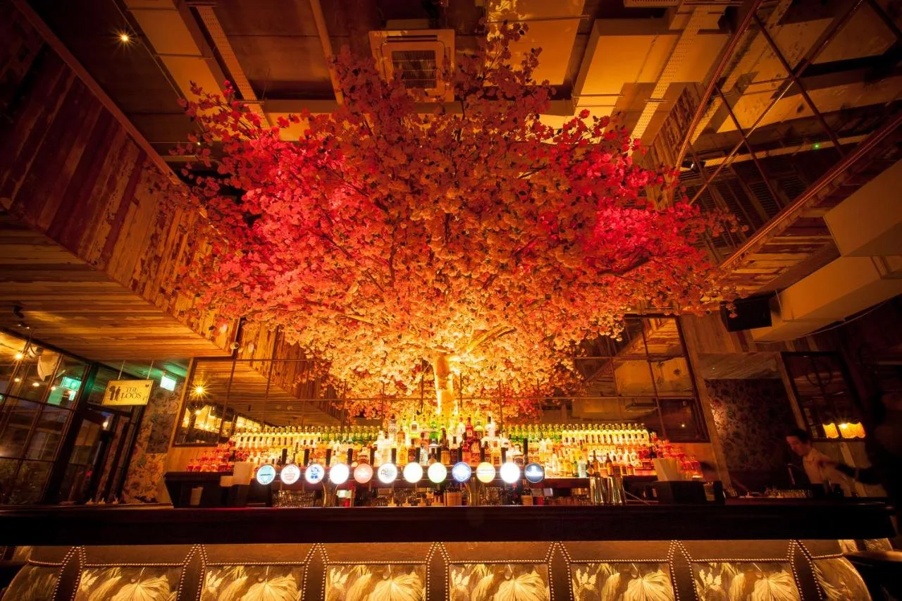 a large chandelier hanging from the ceiling of a restaurant at House Belfast Hotel in Belfast